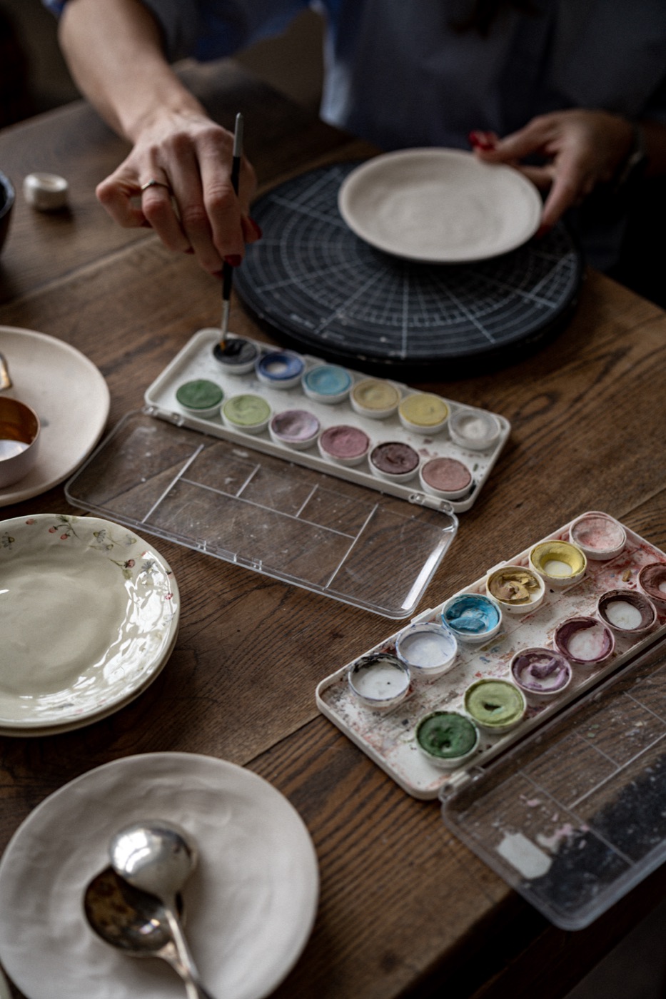Agnes BR painting a bowl with a palette of natural pigments