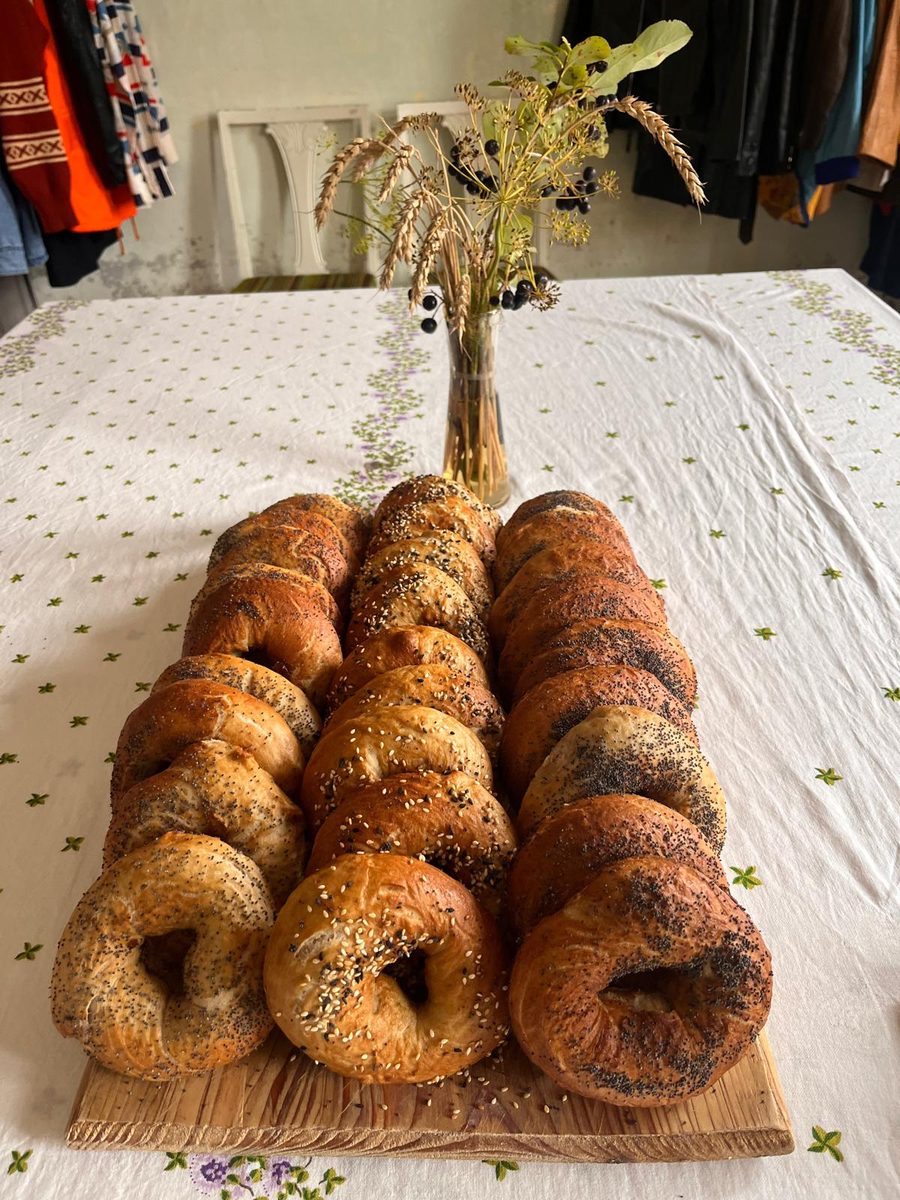 Rows of freshly baked sourdough bagels on a wooden board